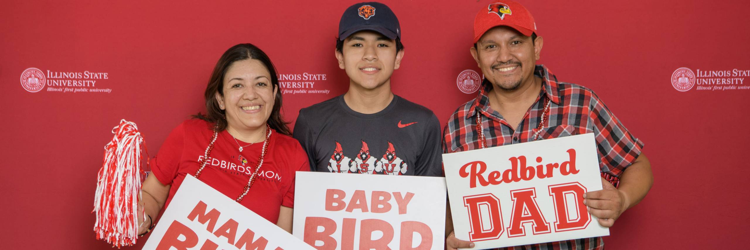 Mom, student, and father pose in front of Redbird background